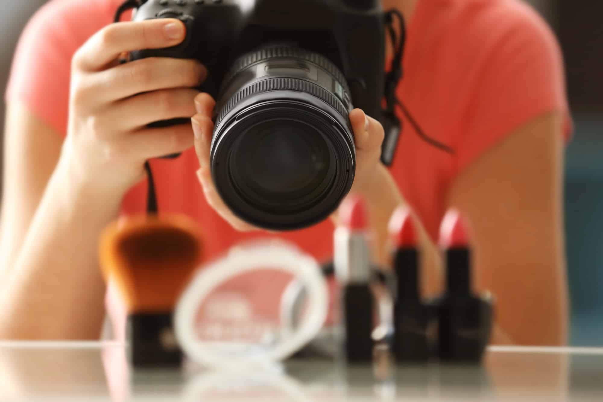 Young woman taking closeup pictures of makeup kit